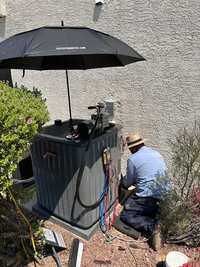 HVAC technician performing outdoor AC maintenance in Needham